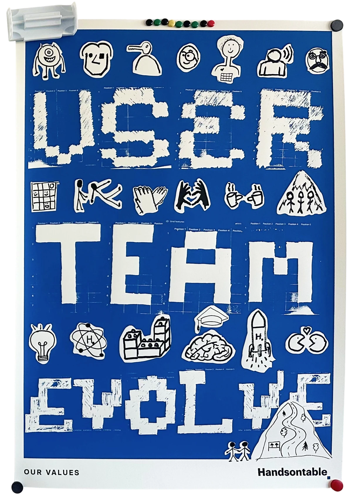The Handsontable values poster pinned to a flip chart: USER, TEAM and EVOLVE spelled out in white on blue, surrounded by hand-drawn stickers, captioned OUR VALUES